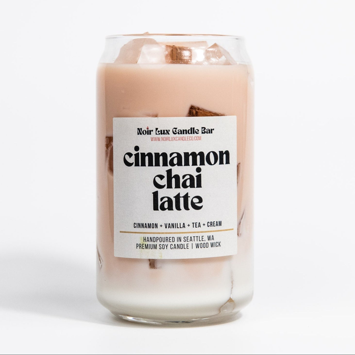 Candle labeled 'cinnamon chai latte' on a white background