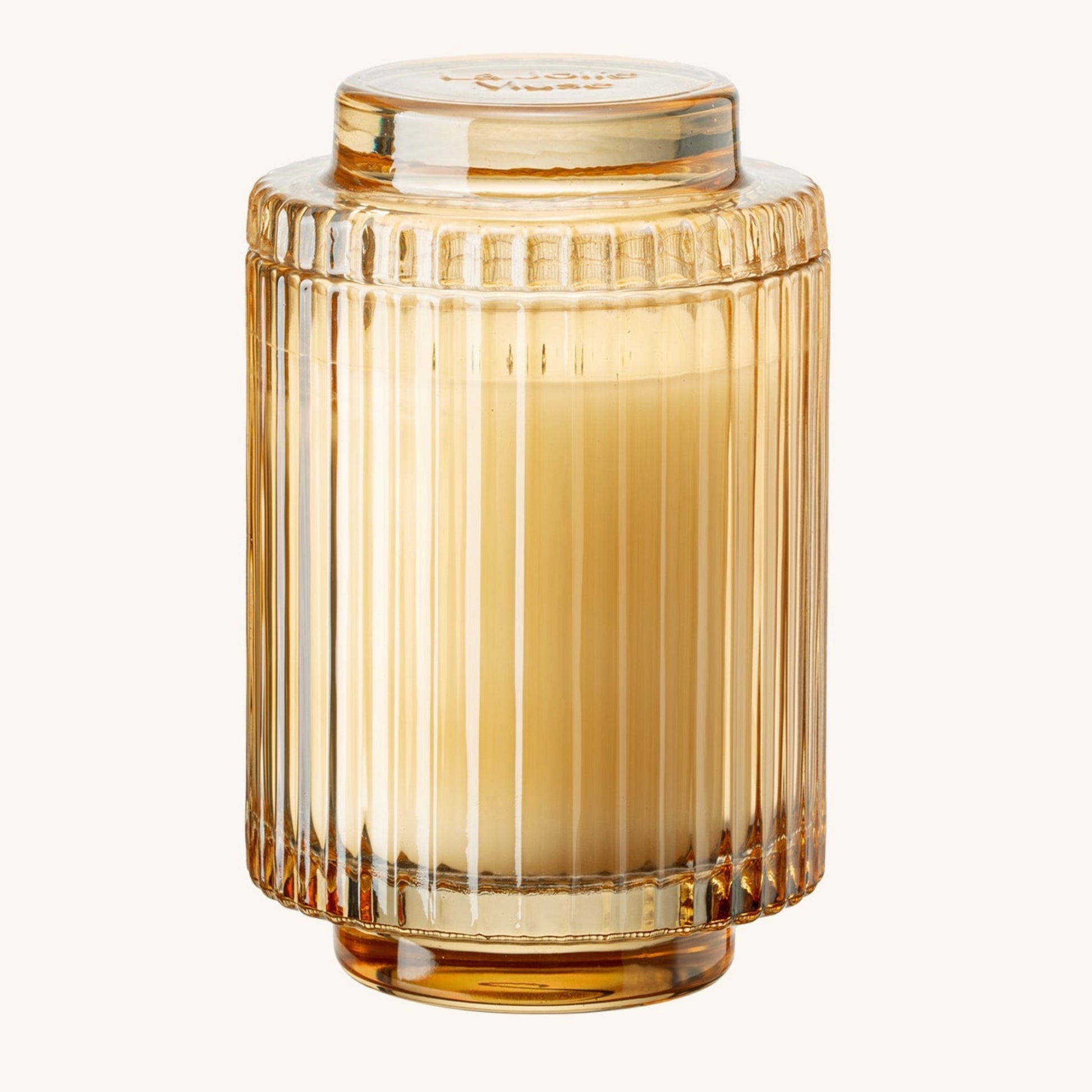 Gold glass vase with ribbed design on a white background